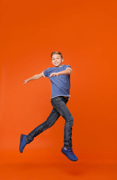 Man jumping and celebrating with arms raised with sunset in the background. Man jumping for joy, feeling happy and free.
