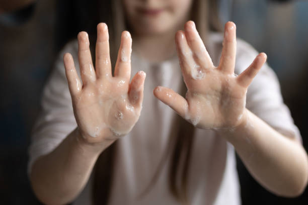 istock Young girl washes hands with soap 2197113401