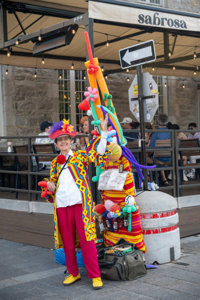 Montreal, Canada - July 4, 2024. A dressed-up lady selling balloons on street in the old town of Montreal, Quebec, Canada