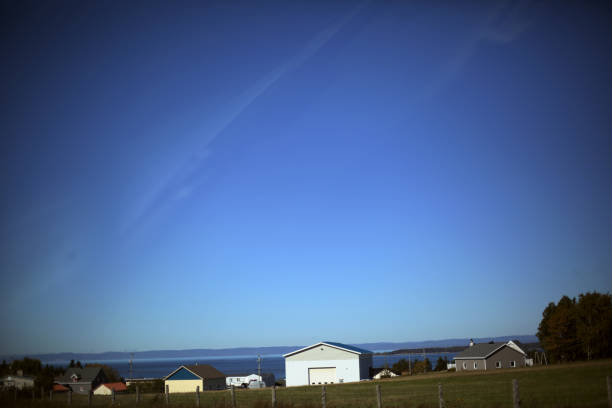 Shot of a small rustic village by the sea under clear sky. Taken in Gaspesie, Quebec, Canada, during the day.