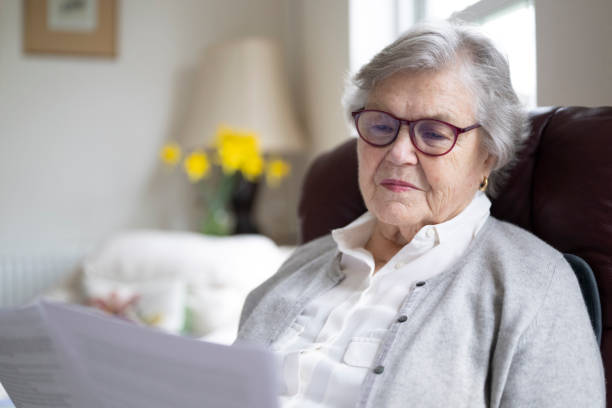 istock Senior woman reading documents at home 2197117192