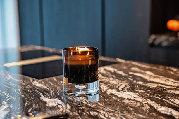 istock Lit Candle on Polished Marble Surface in Modern Dark Interior 2197118428