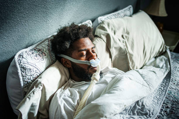 Young African American Man in His Twenties Sleeping Soundly Using a CPAP Machine for Sleep Apnea
