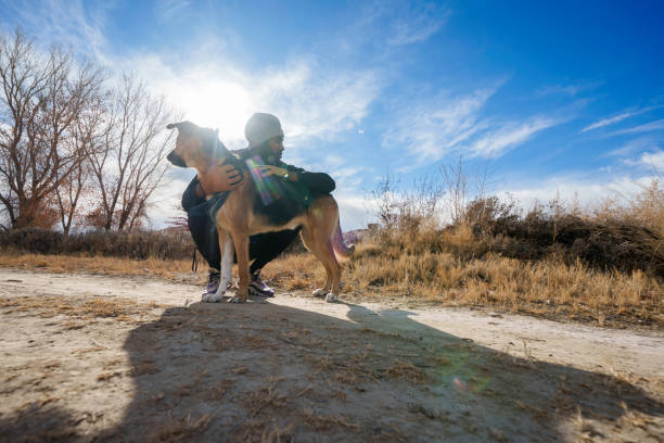 Young Athletic African American Man Walking and Posing Outside with his German Shepherd Dog On a Sunny Winter Day