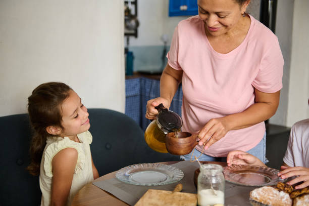 istock Mother Sharing Tea With Her Children Around the Kitchen Table 2197125550