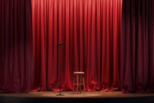 istock Stand-up stage with a microphone. An empty theater stage with red velvet curtains. 2197128229