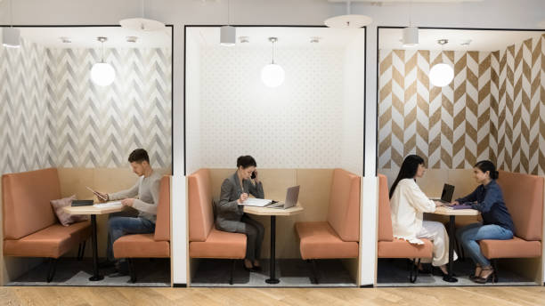 istock Multiethnic freelancers working in separate booths in modern freelance co-working 2197128605