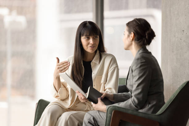 istock Two female office friends chatting in office lobby on break 2197128810