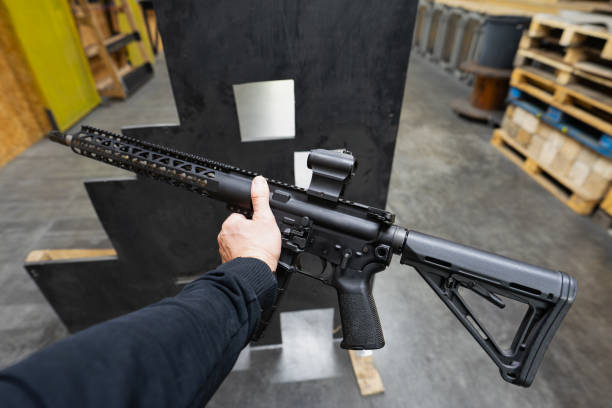 istock Tactical shooting, rifle with collimator sight in a man's hand at a shooting range. 2197129171