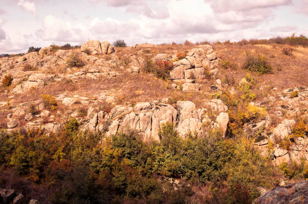 fantastic autumn in a mountain canyon, huge rocks. Mountains of large granite boulders, stone ledges for mountaineering and walking. trees and meadows grow among the rocks. Aktovsky Canyon, Ukraine.