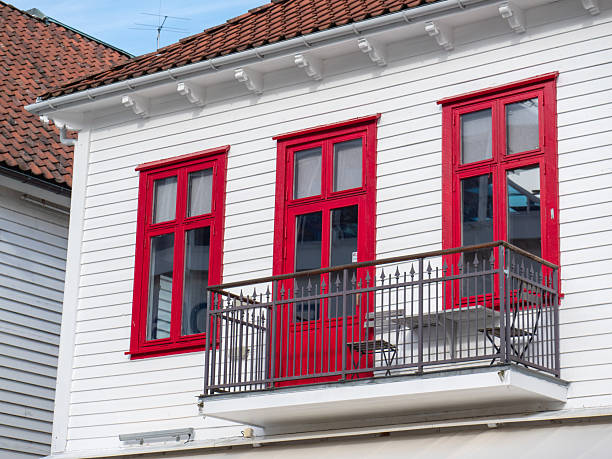 istock White wooden house with red window frames and balcony 2197130785