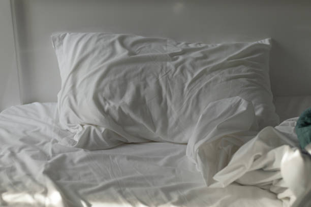 istock unmade bed, white bed linen on bed in hotel room 2197136269