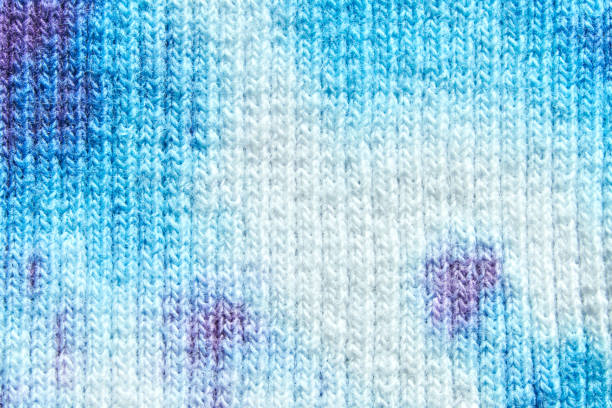 Abstract blue and white textile pattern with purple accents close up