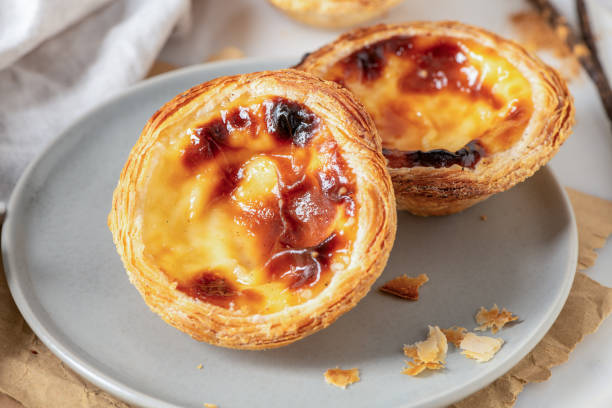 istock Pastel de Nata on a plate with willow branches, a traditional Portuguese custard tart. Top view. 2197149337