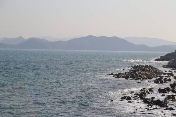 The ocean is calm and the sky is clear. The mountains in the background create a sense of serenity and peace
