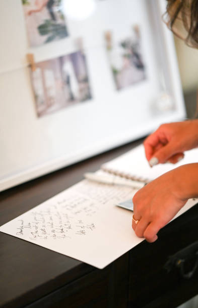 istock Close up of a woman's hand writing on a guest book 2197158521