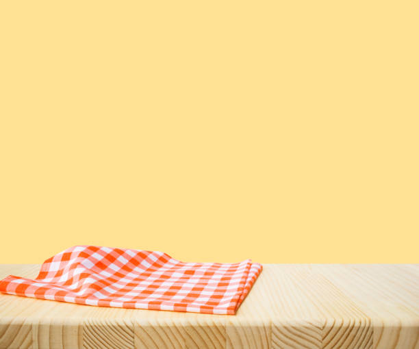 istock Fabric cloth or placemat on wood table top on yellow pastel 2197162212