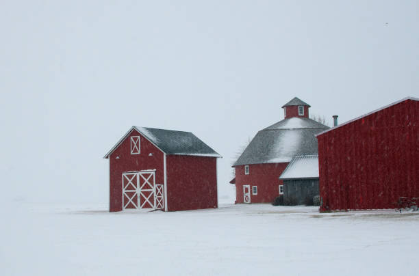 Falling snow and a red barn surround in snow seen in rural North Carolina