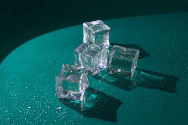 istock Transparent ice cubes with shadows on a dark green surface 2197168036