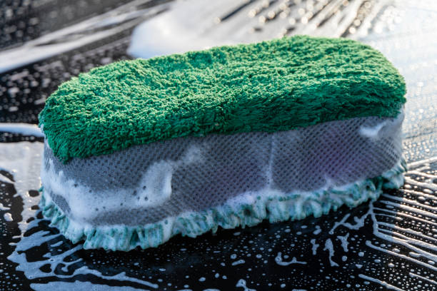 Cleaning sponge in foam of dishwashing liquid. Washing dishes concept
