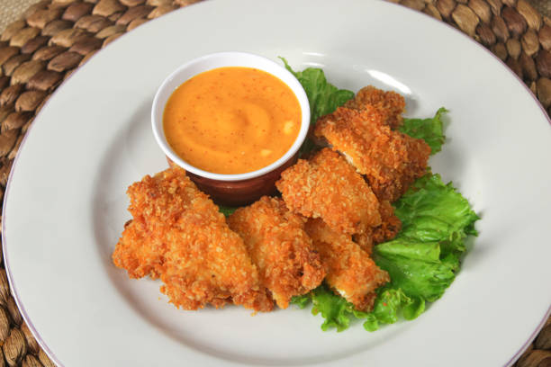 istock Crispy chicken nugget pieces with spicy cheese sauce 2197171989