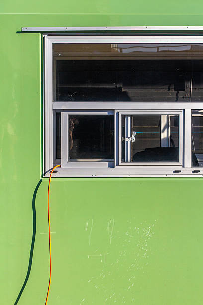istock Minimal Green Facade with Open Window and Bright Orange Cable 2197175001