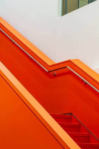 Vibrant architectural photograph of an orange staircase with clean lines, emphasizing modern minimalism. The structure highlights geometric aesthetics and contemporary interior design elements with bright, striking orange tones.