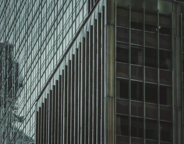 istock Sleek, modern Hong Kong building facade.  Geometric lines and glass panels create a striking architectural detail.  The interplay of light and shadow emphasizes texture and depth. 2197175217