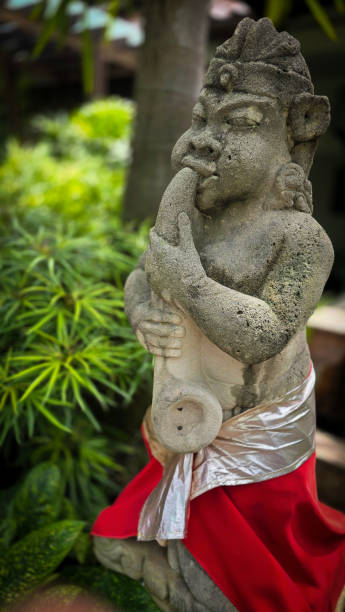 istock Garden Gnome traditional stone statue situated in a tranquil tropical garden, surrounded by vibrant foliage and artistic decor, harmonizing with the natural beauty of its environment 2197175415