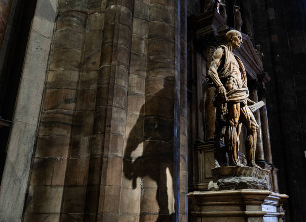 A strikingly dramatic marble statue of Saint Bartholomew, depicted with an exposed musculature, holding his own flayed skin and a sacred book. Located in the Cathedral of Milan