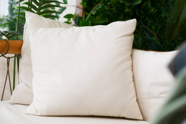 Lighting aroma scented candles and decorative item on wooden table across fabric sofa in living room. Calm and Soothing, Product Display, Cosy Atmosphere.