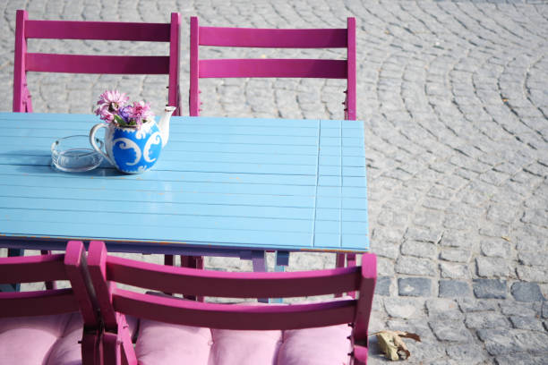 A lively outdoor cafe with a blue table and pink chairs, creating an inviting atmosphere