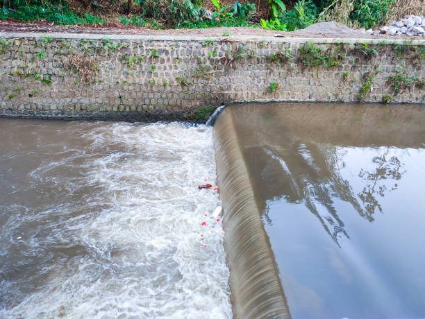istock Small Weir on a Calm River with Plants Nearby 2197184025