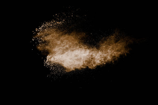 istock Black background with a cloud of brown dust and a few particles. 2197190730