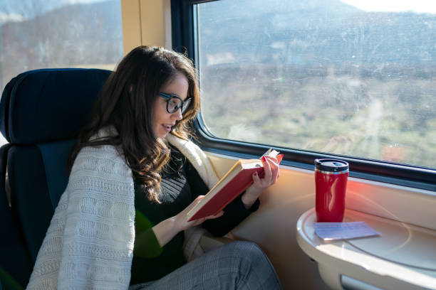 istock Young female passenger reading book while traveling by train 2197195845