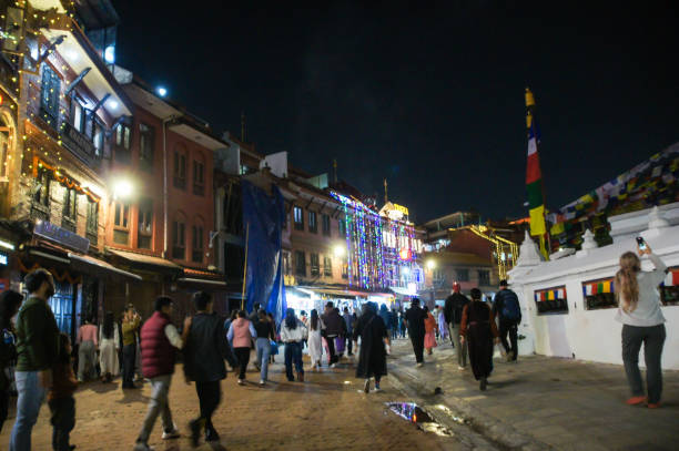 Walking tour of Kathmandu in the evening.\nKathmandu, Nepal - 3, November, 2024.\nA crowd of people walks along a brightly lit evening street.