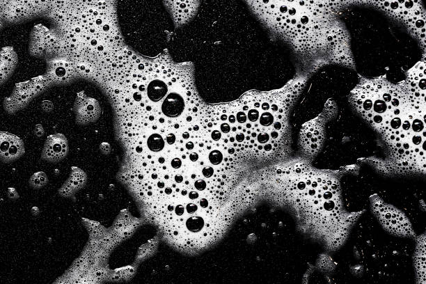istock Foam texture. White bubbles on a black background. Washing a frying pan. Soapy texture. 2197196428