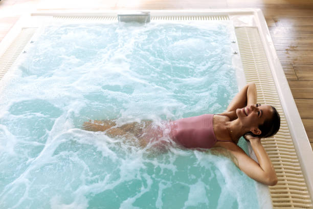 istock Young beautiful woman relaxing at the indoor pool 2197196593
