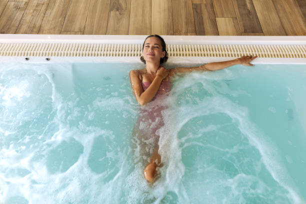 istock Young beautiful woman relaxing at the indoor pool 2197196899