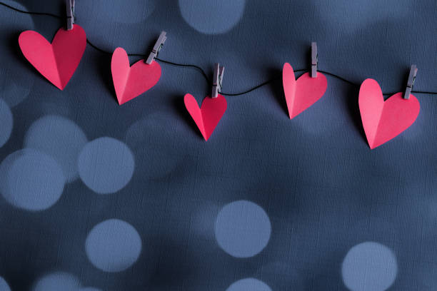 istock Paper hearts on a clothesline with bokeh lights and space for copy 2197198412