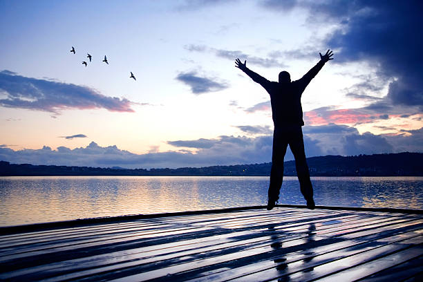 istock Single happy man jumping on beach during sunrise 2197199229