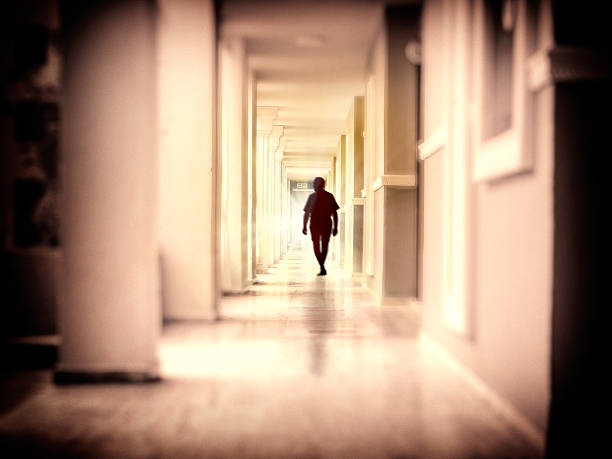istock Single man walking at dark narrow corridor towards glowing door 2197199568