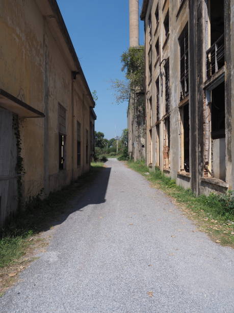 istock Narrow Alley Between Abandoned Industrial Buildings Under Blue Sky 2197200220