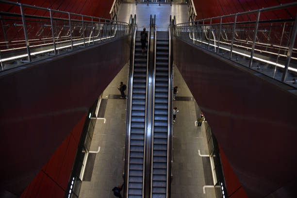 Copenhagen subway station with an escalator and several people.