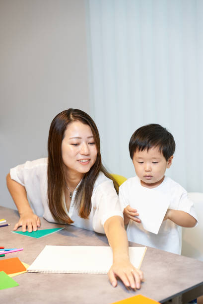 istock Mother and boy playing origami 2197202369