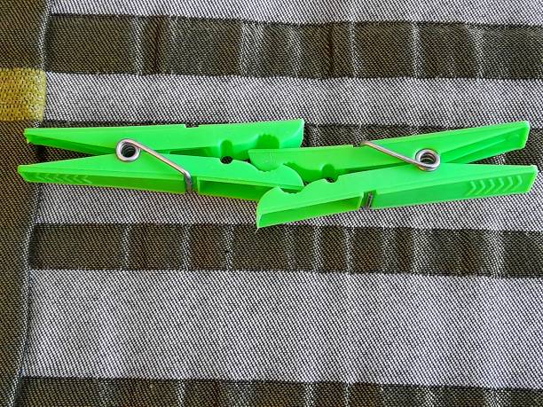 istock Two green clothespins with green background 2197202383