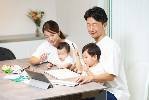 istock A father operating a computer and his family playing nearby 2197203343
