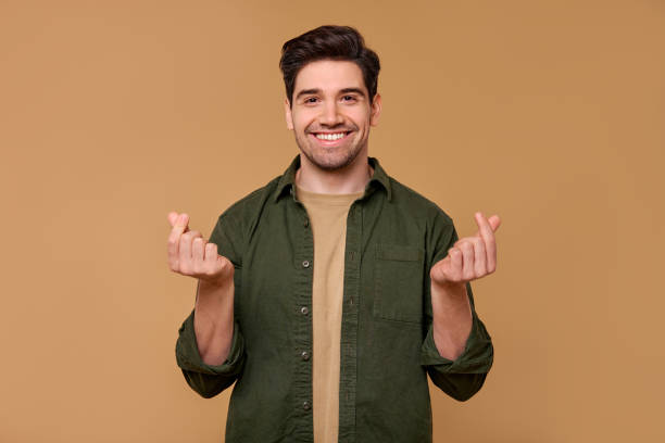 istock A cheerful man with a making money gesture and friendly smile radiates warmth and charisma 2197203620