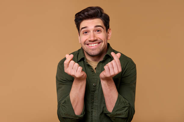 istock A cheerful man with a making money gesture and friendly smile radiates warmth and charisma 2197203632