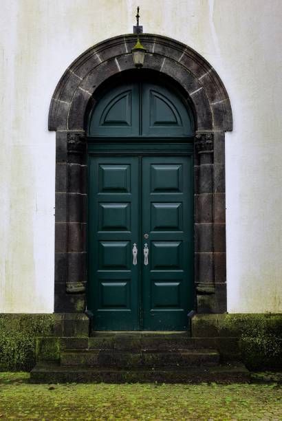 istock Classic green wooden door with arched stone frame. 2197204136